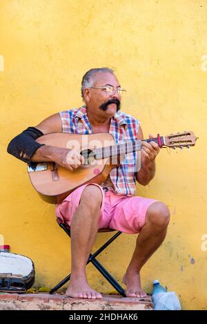 Porträt eines älteren kubanischen Mannes, der auf der Straße in Trinidad Gitarre spielt. Er hat einen großen Schnurrbart. Januar 6, 2022 Stockfoto