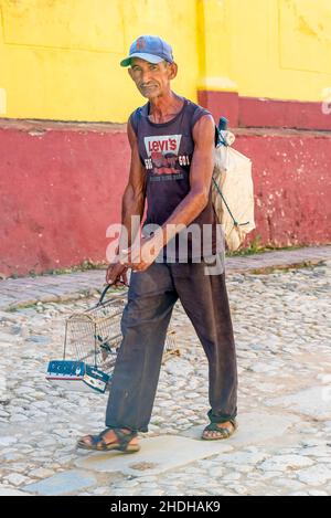 Porträt eines Kubaners, der mit einem Vogelkäfig auf der Straße von Trinidad unterwegs ist. Januar 6, 2022 Stockfoto