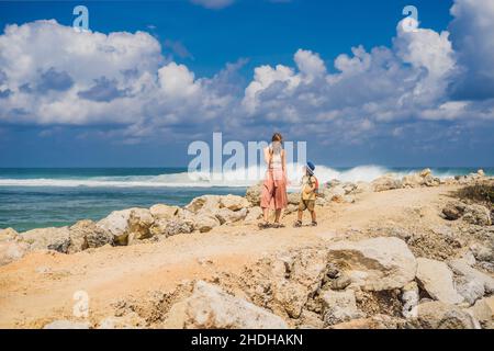 Mutter und Sohn Reisende auf erstaunliche Melasti Strand mit türkisblauen Wasser, Insel Bali Indonesien. Mit Kindern unterwegs Konzept Stockfoto