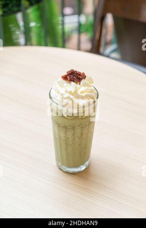 matcha Grüner Tee Latte gemischt mit Schlagsahne und roten Bohnen in Café und Restaurant Stockfoto