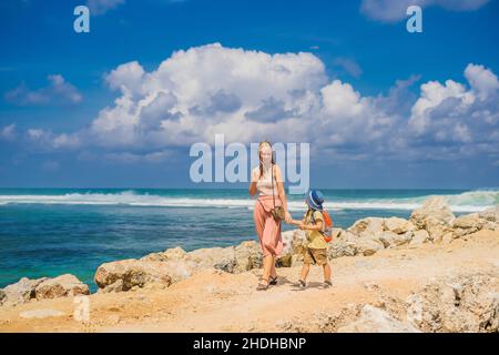 Mutter und Sohn Reisende auf erstaunliche Melasti Strand mit türkisblauen Wasser, Insel Bali Indonesien. Mit Kindern unterwegs Konzept Stockfoto