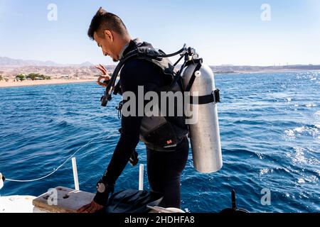 Ein Taucher bereitet sich auf den Tauchgang im Roten Meer vor, Aqaba, Aqaba, Jordanien. Stockfoto