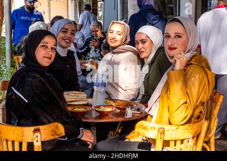 Eine Gruppe junger jordanischer Frauen genießt das Frühstück vor einem Café in Aqaba, Governorate Aqaba, Jordanien. Stockfoto