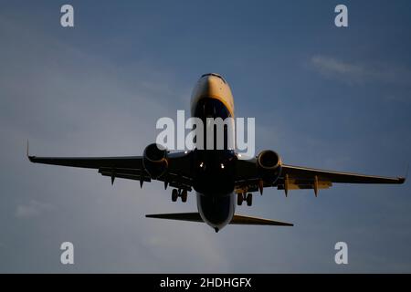 Passagiere Verkehrsflugzeug fliegen über Wolken in Sonnenuntergang Licht. Konzept für schnelle Reisen, Urlaub und Business. Stockfoto