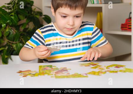Ein Vorschulkinder spielt Puzzles, stellt ein Bild zusammen Stockfoto