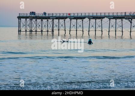 Surfer am Saltburn Pier bei Sonnenaufgang am Neujahrstag 2020 Stockfoto