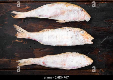 Frozen Goatfish rohes Fischset, auf altem dunklen Holztisch Hintergrund, Draufsicht flach liegend Stockfoto