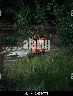 Indigene Kinder rudern den Amazonas entlang, Ecuador Stockfoto