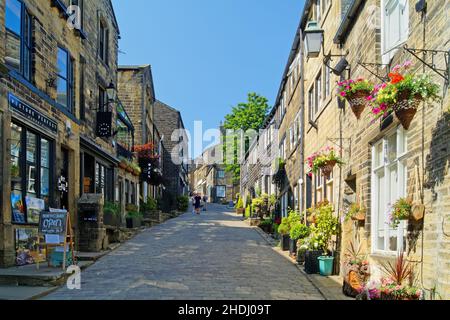 Großbritannien, West Yorkshire, Haworth, Geschäfte und Hütten an der Main Street Stockfoto