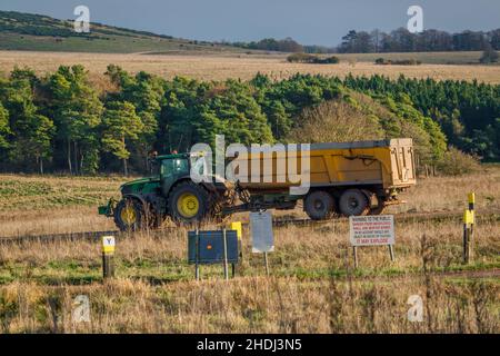 Großer John Deere 6215R Traktor, der einen 12 Tonnen schweren Kippanhänger schleppt Stockfoto