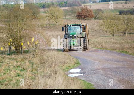 Großer John Deere 6215R Traktor, der einen 12 Tonnen schweren Kippanhänger schleppt Stockfoto