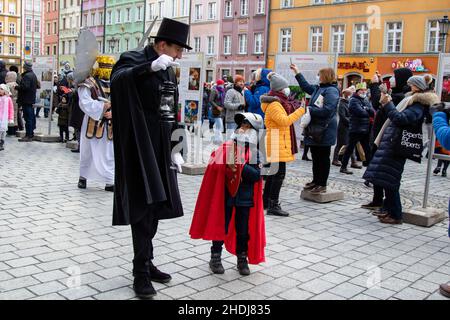 Breslau, Polen. 06th Januar 2022. Der Wroclaw lamplighter in einer schwarzen Robe mit einem Jungen, der als polnischer Ritter gekleidet ist, führt die Epiphanie-Prozession, die auch als Prozession der drei Könige bekannt ist, entlang der Straßen des Nowy Targ Platzes. Kredit: SOPA Images Limited/Alamy Live Nachrichten Stockfoto