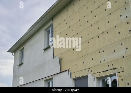 Isolierung eines Wohngebäudes. Außenreparaturen am Gebäude, Dämmung und Verkleidung der Fassade des Hauses. Hochwertige Fotos Stockfoto