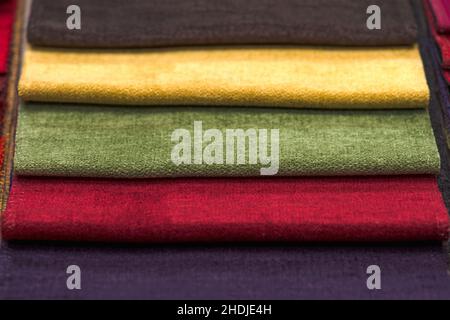 Muster von Textilien für die Polsterung. Detailansicht von mehrfarbigen Stofftexturproben. Muster in verschiedenen Farben: Rot, blau, gelb, grün, braun Stockfoto