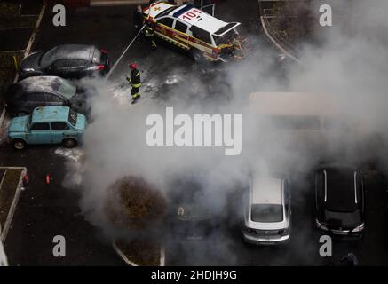 Kiew, Ukraine. 7. Oktober 2021. Feuerwehrleute löschen brennendes geparktes Auto Stockfoto