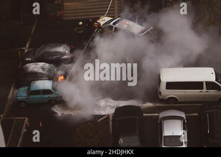 Kiew, Ukraine. 7. Oktober 2021. Feuerwehrleute löschen brennendes geparktes Auto Stockfoto