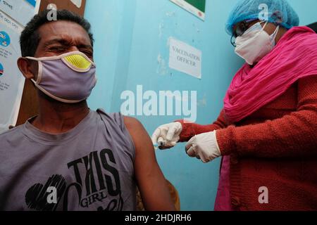 Kalkutta, Indien. 06th Januar 2022. Ein Gesundheitsmitarbeiter verabreicht einem Mann im Madhyamgram Rural Hospital, Kalkata, eine Dosis Covishield-Impfstoff.Indien steht vor einer massiven Anhebung der Covid-19-Fälle, berichtete über 90000 Fälle und 325 Todesfälle in den letzten 24 Stunden, was laut indischen Medienberichten einen starken Anstieg von über 56 % verzeichnete. Govt aus Indien hat den Impfprozess sowie RT-PCR-Tests zur Kontrolle der Ausbreitung des Virus hochgefahren. Kredit: SOPA Images Limited/Alamy Live Nachrichten Stockfoto
