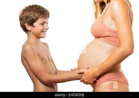 Die Hände des Kindes berühren den Schwangeren Bauch: Erwarten Sie einen Geschwister Stockfoto