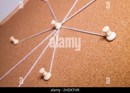 Eine Kork Evidence Board mit mehreren Saiten aus der Mitte Punkt gehen, um Pins um das Brett. Stockfoto