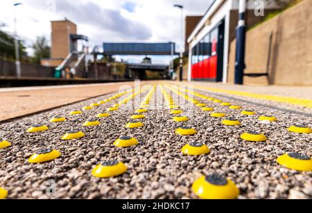 Eine clevere und kleine Möglichkeit, Menschen mit Sehbehinderungen darauf aufmerksam zu machen, dass sie einer Gefahr in der Nähe sind, in diesem Fall dem Bahnsteig. Stockfoto