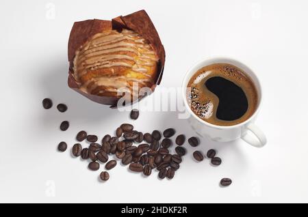 Tasse Kaffee, Muffin mit Schokoladencreme und Bohnen auf weißem Hintergrund Stockfoto