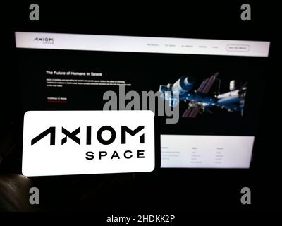 Person, die ein Mobiltelefon mit dem Logo des US-Luftfahrtunternehmens Axiom Space Inc. Auf dem Bildschirm vor der Business-Webseite hält. Konzentrieren Sie sich auf die Telefonanzeige. Stockfoto