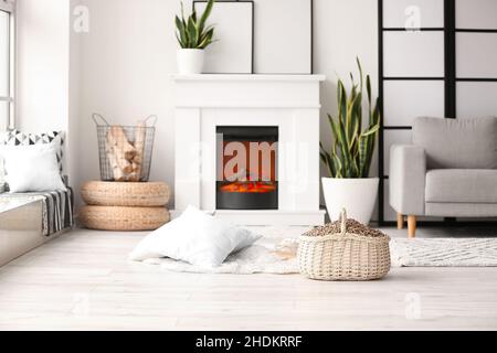 Korb mit Holzpellets im Wohnzimmer Stockfoto