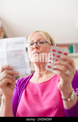 Frau, Senior, Medizin, Beipackzettel, Einnahme von Tabletten, Weiblich, Damen, Dame, Frauen, Senioren, Alt, Senioren, Medikamente, Anleitungsbroschüren, Stockfoto