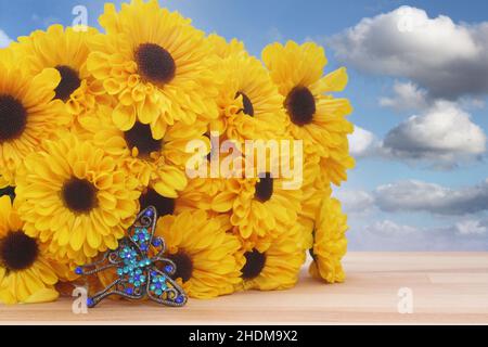 Schmuck mit gelben Blumen und Schmetterlingen mit blauem Himmel und Wolken Stockfoto