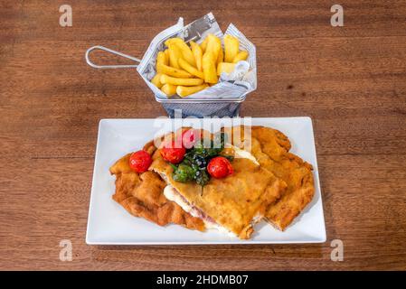 Der Cachopo ist ein charakteristisches Gericht der Gastronomie von Asturien in Spanien. Es besteht aus zwei großen Rinderfilets, zwischen denen Serrano ha gelegt wird Stockfoto