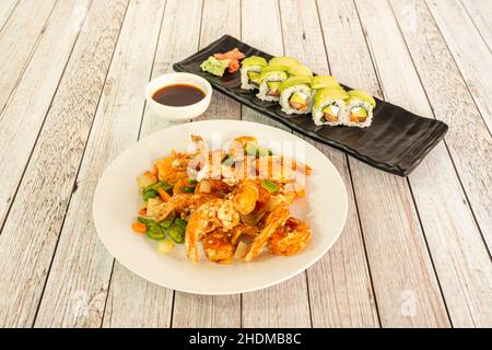 Menü mit würzigen Garnelen in Tempura gebraten, garniert mit Gemüse und Uramaki-Rolle mit Frischkäse und Avocado Stockfoto