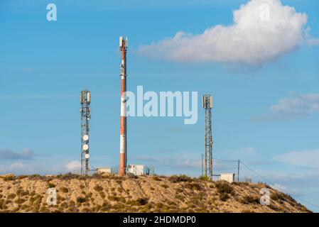 Telekommunikationsmasten auf einem Hügel oberhalb von Camposol, Murcia, Spanien. Verschiedene, mehrere Masten mit Geschirr und Hütten, Gebäude Stockfoto