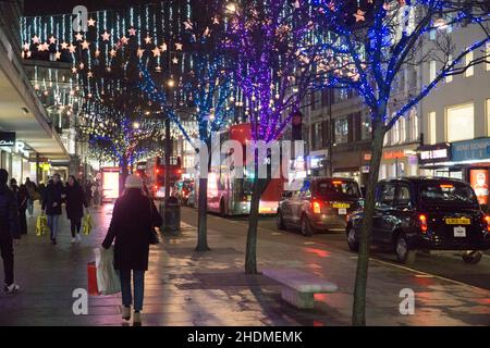 London, Großbritannien, 6. Januar 2022: Shopper am frühen Abend auf der Oxford Street, da die Umsätze im Januar weiter anhalten. Die Besucherfrequenz ist gegenüber der Vorpandemie deutlich gesunken, aber die Geschäfte sind geöffnet und die Kunden sind gemäß den geltenden Plan-B-Vorschriften verpflichtet, Gesichtsmasken zu tragen. Anna Watson/Alamy Live News Stockfoto