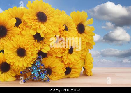 Schmuck mit gelben Blumen und Schmetterlingen mit blauem Himmel und Wolken Stockfoto