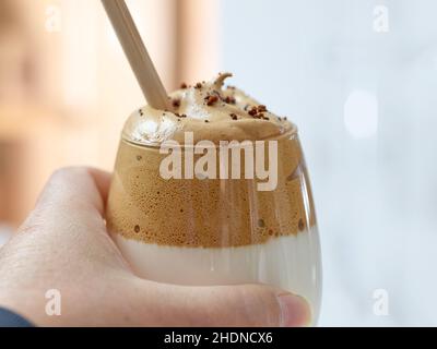 Nahaufnahme des Dalgona-Kaffeegetränks in einem Glas mit Strohhalm, selektiver Fokus Stockfoto