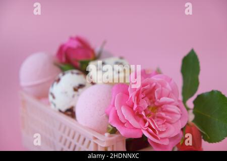 Blume Badebomben.Badebomben und Trüffel mit Rosenblüten in einer rosa Schachtel auf einem rosa Hintergrund.Badebomben mit Rosenextrakt.Schönheit und Aromatherapie Stockfoto