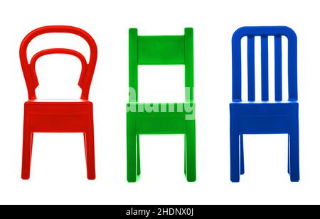 Drei kleine Plastikstühle. Rot-grüne und blaue Kleiderbügel mit Wandhalterungen isoliert auf weißem Hintergrund. Stockfoto