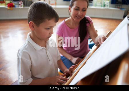 Klavierunterricht, Musikschule, Musikschüler, Klavierlehrer, Klavierunterricht, Musikschulen, Schüler, Studenten, Klavierlehrer Stockfoto