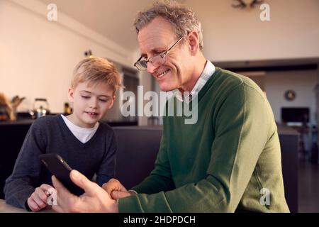 Enkel, Großvater, Hilfe, mobil, Enkel, Großväter, helfende, mobile Geräte Stockfoto