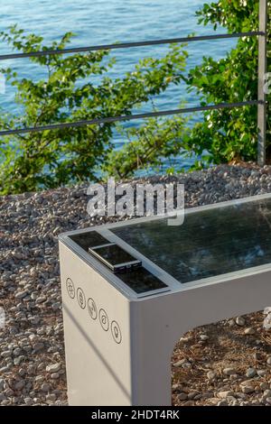 Smart Solar Bench in öffentlichen Raum, powered by Sunlight bietet drahtlose und kabelgebundene Aufladen für Benutzer, kostenlose WLAN-und Temperatur-und Wettersensoren. Stockfoto