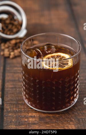 Erfrischende Eiskaffee-Limonade in Kristallglas-Tasse auf Holztisch Stockfoto