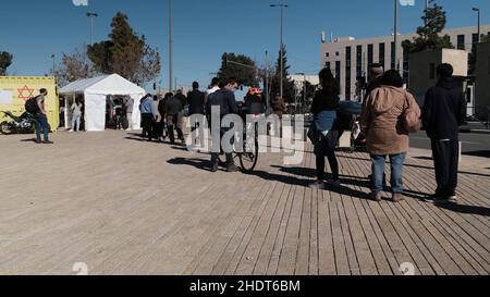 Jerusalem, Israel. 6th Januar 2022. Vor einer mobilen COVID-19-Teststation, die vom nationalen medizinischen Notdienst „Magen David Adom“ betrieben wird, warten Menschen Schlange, da Israel als erstes Land der Welt am 6. Januar 2022 in Jerusalem, Israel, eine vierte Impfkampagne gegen COVID-19 einführt. Israel begann damit, Menschen über 60 Jahren und im Gesundheitswesen vierte Dosen des Pfizer-Coronavirus-Impfstoffs zu verabreichen, als Teil der Bemühungen, die durch die Omicron-Variante rasch steigenden Infektionsraten einzudämmen. Kredit: Eddie Gerald/Alamy Live Nachrichten Stockfoto