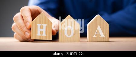 Hand platzieren Holzhaus HOA Blöcke über dem Schreibtisch Stockfoto
