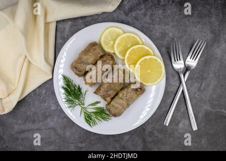 Gefüllte Kohlblätter, in einer Keramikplatte. Vegane Kohlrollen, gekochte Kohlblätter, umwickelt um eine Füllung aus Reis, Zwiebeln und Gewürzen. (Lahana s Stockfoto