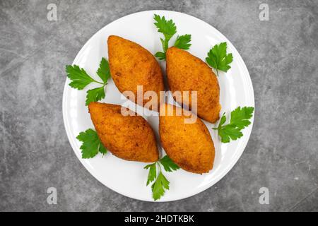 Kibbeh auf dunklem Hintergrund. Kibbeh ist ein beliebtes Gericht in der nahöstlichen Küche. Gefüllte Fleischbällchen Essen, Falafel, icli Kofta, Quibe. Draufsicht. Schließen Sie U Stockfoto