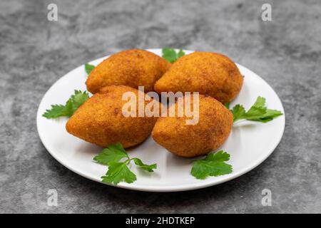 Kibbeh auf dunklem Hintergrund. Kibbeh ist ein beliebtes Gericht in der nahöstlichen Küche. Gefüllte Fleischbällchen Essen, Falafel, icli Kofta, Quibe. Horizontale Ansicht. Stockfoto
