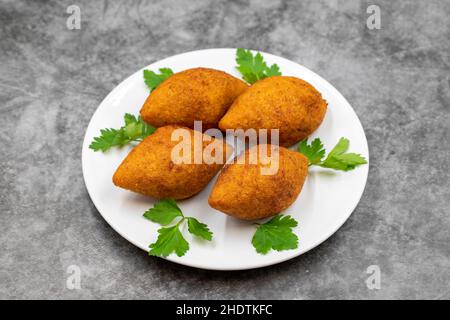Kibbeh auf dunklem Hintergrund. Kibbeh ist ein beliebtes Gericht in der nahöstlichen Küche. Gefüllte Fleischbällchen Essen, Falafel, icli Kofta, Quibe. Horizontale Ansicht. Stockfoto