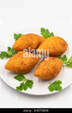 Kibbeh auf weißem Hintergrund. Kibbeh ist ein beliebtes Gericht in der nahöstlichen Küche. Gefüllte Fleischbällchen Essen, Falafel, icli Kofta, Quibe. Vertikale Ansicht. Clo Stockfoto