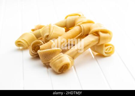 Delikatesse für Hunde. Kauknochen für Hund auf weißem Tisch. Stockfoto
