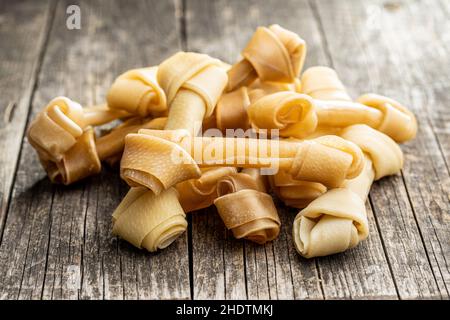 Delikatesse für Hunde. Kauknochen für Hund auf Holztisch. Stockfoto